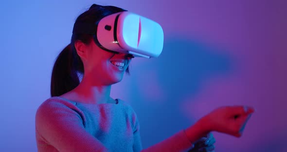 Woman looking though virtual reality device over red and blue light