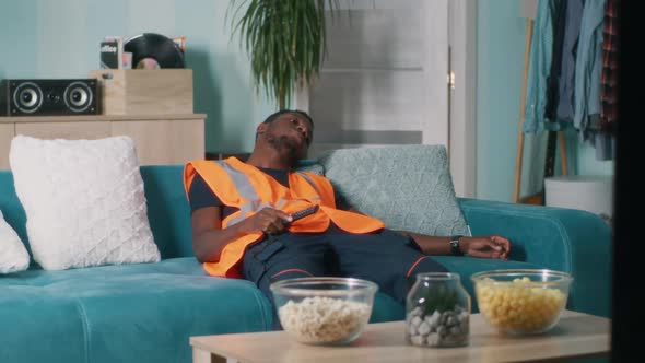 Exhausted African American Worker Watching TV at Home