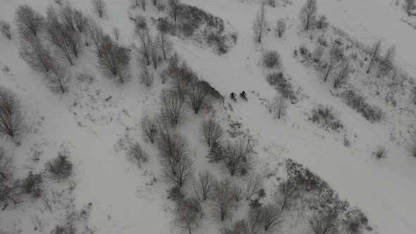 two guys riding motorcycles in the snow	