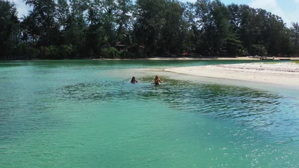 Ladies together enjoying life on perfect sea view beach lifestyle by turquoise sea with white sand b