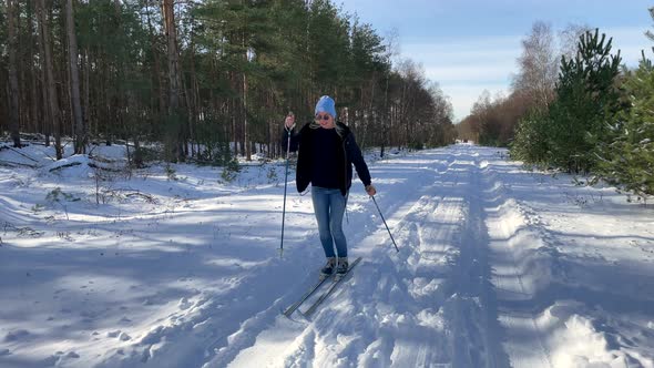 Woman Slides With Skis And Poles On The Snow On A Sunny Day. slow motion