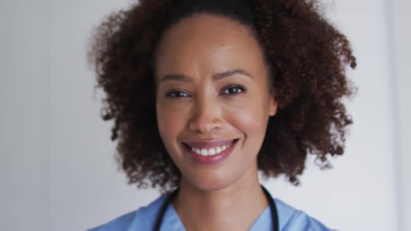 Portrait of mixed race female doctor looking at camera and smiling