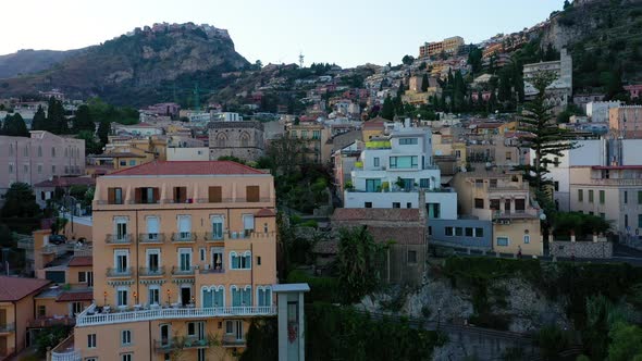 Old Italian town on top of the cliff. Drone elevates to reveal colorful cityscape. Houses on the edg
