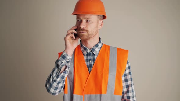 Confident builder talking by phone