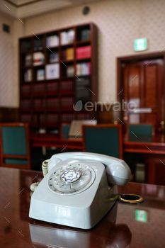 Selective focus of a rotary dial phone with furniture on the background