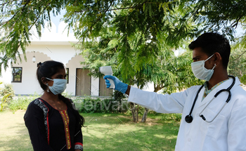 Indian doctor wearing a facemask and using an infrared thermometer