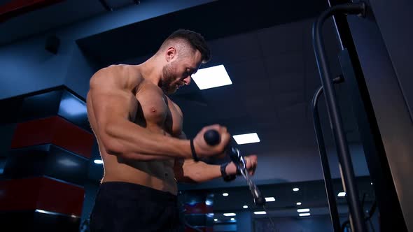 Young handsome man doing exercises in gym