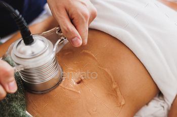 tation treatment to fat reduction on abdomen at the beauty salon.