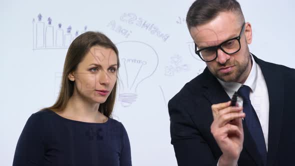 Man and Woman Discuss the Business Strategy for Success in a Modern Glass Office