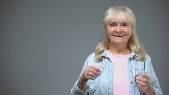Smiling Aged Lady Showing Pills Medication Quality, Immunity Strengthening Drugs