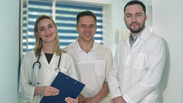 Two Male Doctors and Female Doctor with Stethoscope Smiling To the Camera