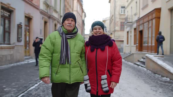 Senior Elderly Couple Tourists Man Woman Walking Along Street in Winter City Enjoying Time Together