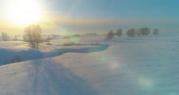 Aerial View of Cold Winter Landscape Arctic Field Trees Covered with Frost Snow Ice River and Sun