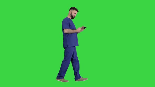 Surgeon Doctor Walking and Using His Phone on a Green Screen, Chroma Key.