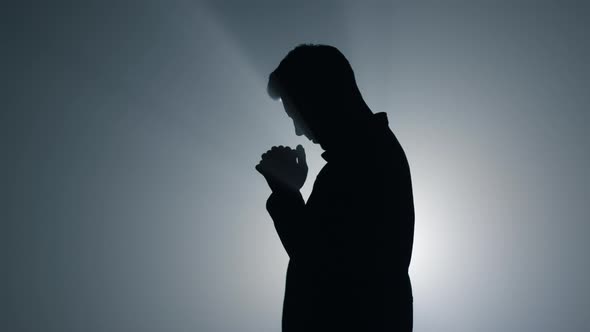 Silhouette Man Asking God Blessing in Darkness