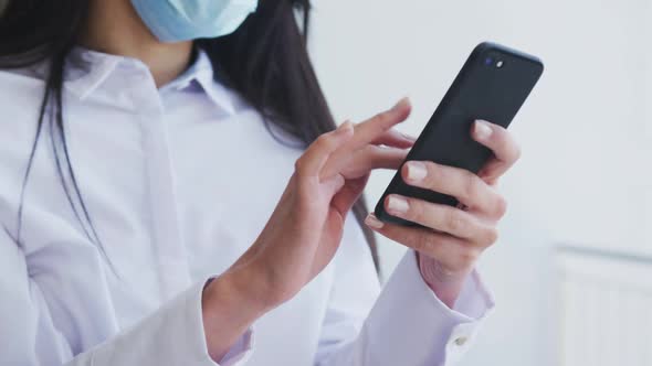 Woman wearing face mask using smartphone