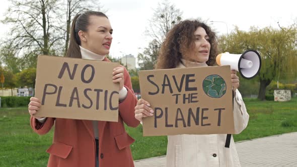 Two Women are Standing with Posters SAVE THE PLANET and NO PLASTIC