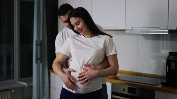 Husband Gently Stroking Pregnant Wife Tummy Indoors in Slow Motion