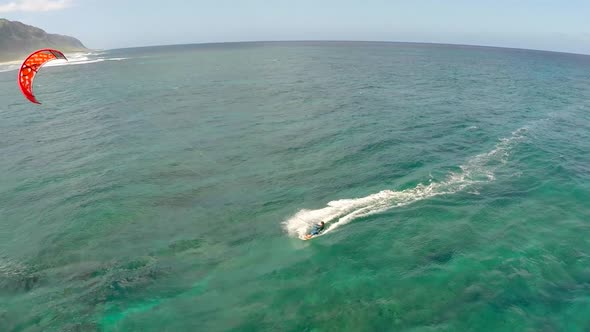 Aerial view of a man kitesurfing in Hawaii.