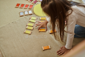 montessori material, smart girl playing  educational color game in shape of sun, early education