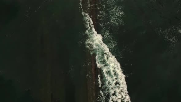 Stormy sea waves splashing on rocky cliff