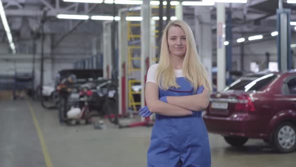 Portrait of Blond Confident Caucasian Woman in Blue Workrobe Standing in Repair Shop, Looking at