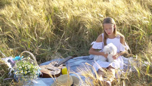 Beautiful Little Girl in Wheat Field with Ripe Wheat in Hands