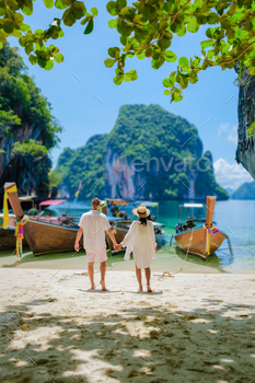 beautiful beach with longtail boats, a couple of European men, and an Asian woman on the beach. Couple on a boat trip