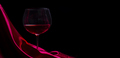 Glass of red wine on red silk against black background.  - PhotoDune Item for Sale