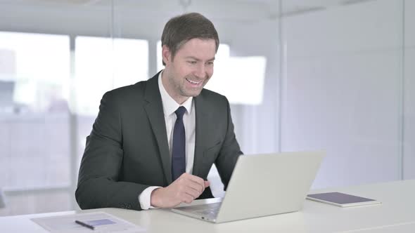 Ambitious Businessman Celebrating Success on Laptop