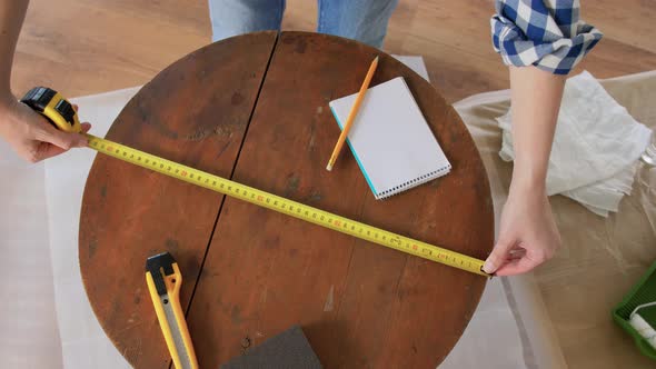 Woman with Ruler Measuring Table for Renovation