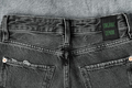 Black jeans labeled ORGANIC DENIM. Sustainable fashion, conscious consumption, trendy clothing. - PhotoDune Item for Sale