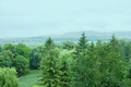 Summer landscape with green trees, hills, cloudy sky, foggy wet weather. - PhotoDune Item for Sale