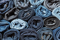 Lots of rolled up jeans. Denim background. Trendy denim clothing, shopping, fashion, consumption. - PhotoDune Item for Sale