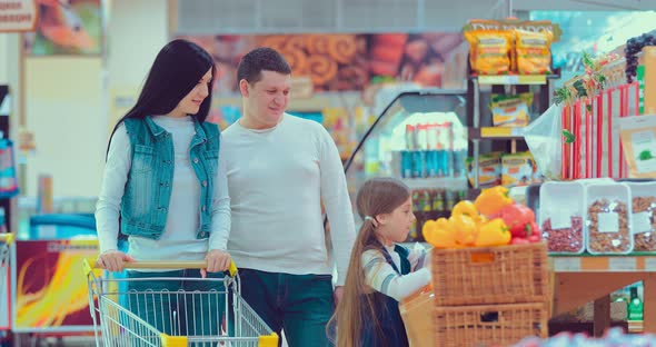Mother Father and Children Collect Oranges in a Package in a Supermarket