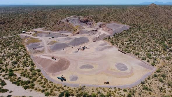 Wide drone shot of a rock quarry and machines working