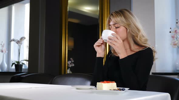 Portrait of Relaxed Girl Having Coffee Break. Beautiful Romantic Girl with Cup of Coffee or Tea