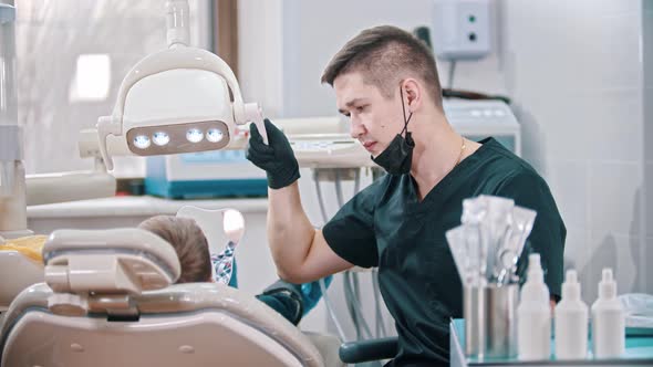 Young Man Dentist Preparing Everything for the Checking the Mouth of a Small Boy