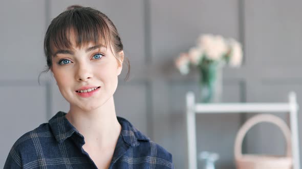 Portrait of Beautiful European Young Woman with Blue Eyes at Modern Home Interior