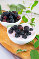 Wild berries naturally on a wooden cutting board with creamy yogurt - PhotoDune Item for Sale