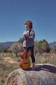 Peaceful child with acoustic guitar standing on haystack in fiel - PhotoDune Item for Sale