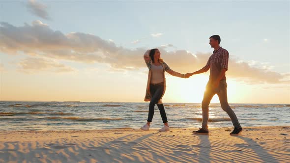 Steadicam Shot: Loving Couple Walking at Sunset on the Beach or Lake. She Leads the Guy Flirting