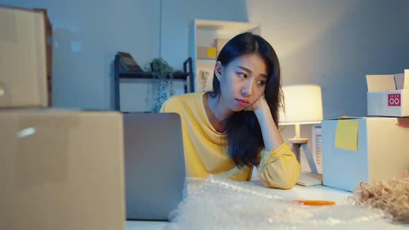 Young Asia businesswoman look around room full of product stuff and parcel box feel stress.