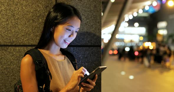 Woman using smart phone in Hong Kong at night 