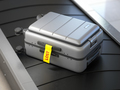 Suitcase with lost sticker on an airport baggage conveyor or baggage claim transporter. - PhotoDune Item for Sale