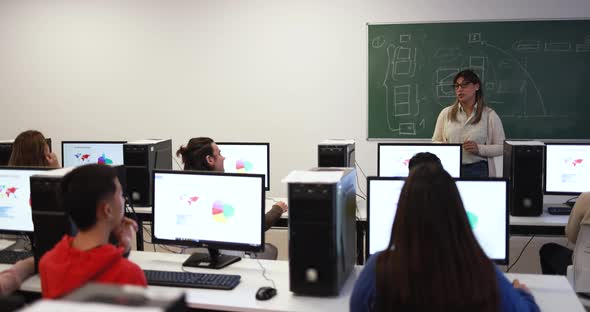 Young multiracial students using computers at school class