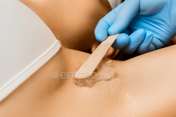  armpit area. Hair removal and spa services. Smearing stretchy structure on woman body part