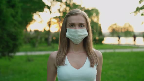 Woman Taking Off Face Mask Outdoors.