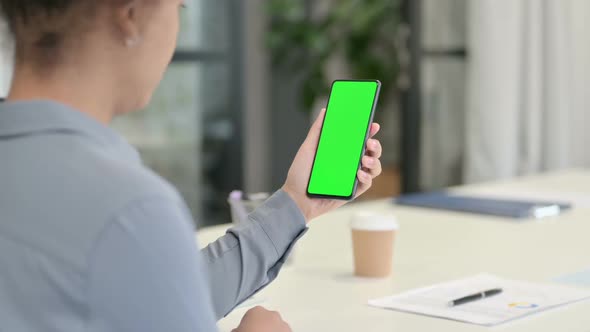 Rear View of African Woman Using Smartphone with Green Chroma Screen