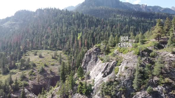 Aerial Pan Above the Mountain Town of Ouray Colorado By Box Canyon Sign